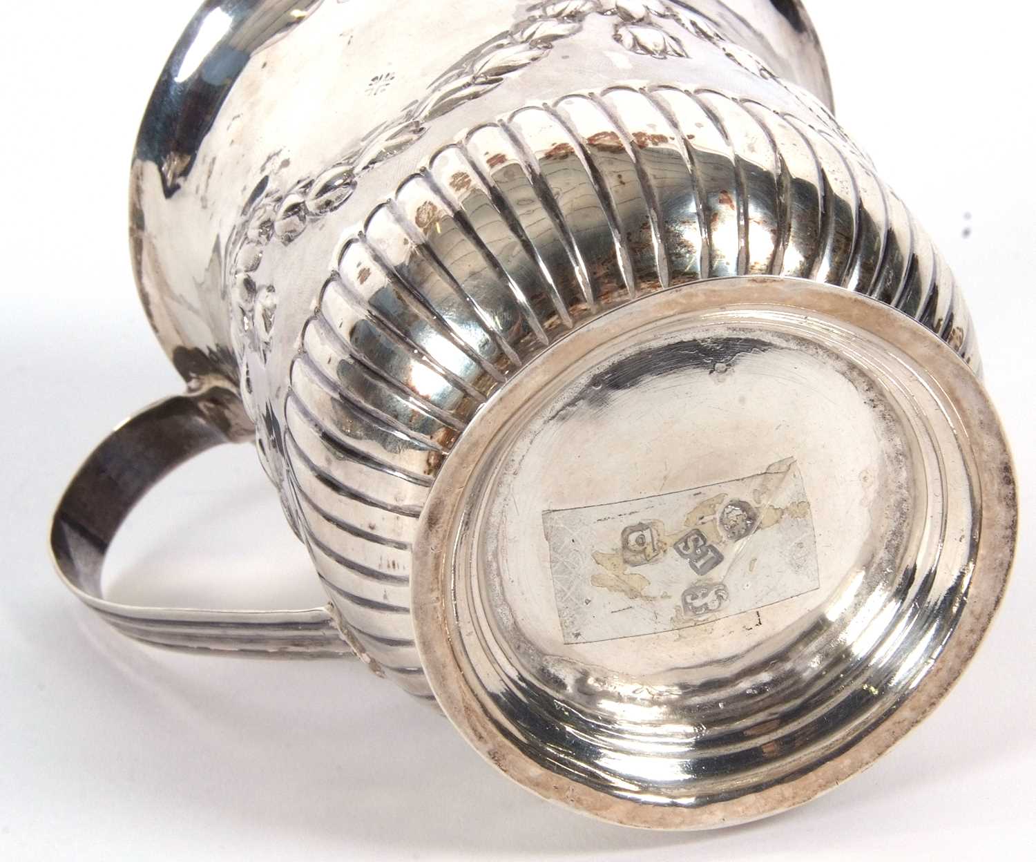 A George III silver mug of slight baluster shape having a reeded handle, garland and fluted - Image 4 of 4