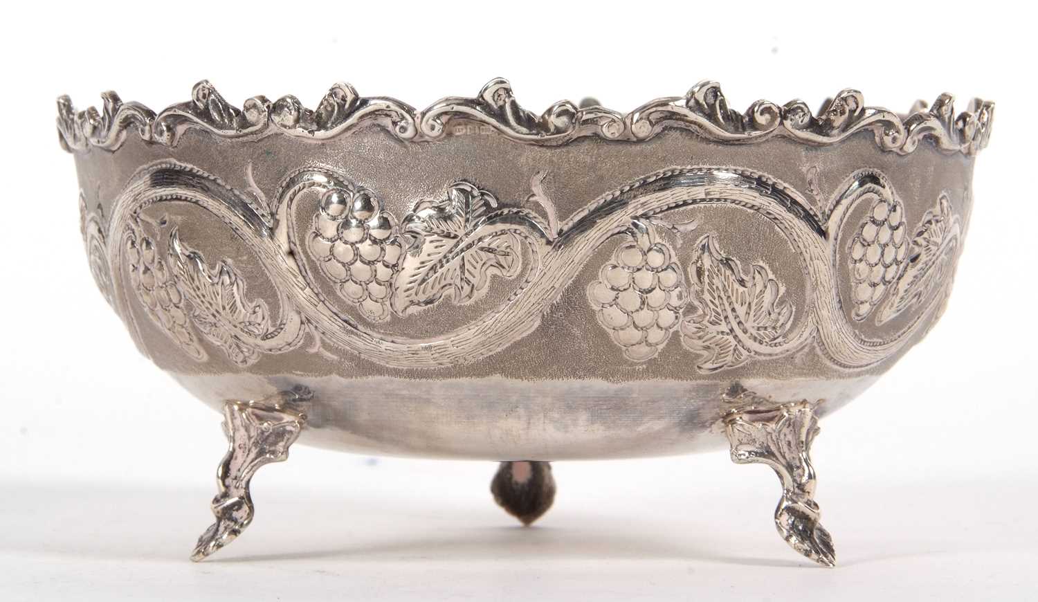 A vintage white metal 830-Cyprus bowl decorated with a vine and grape design and supported on