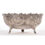 A vintage white metal 830-Cyprus bowl decorated with a vine and grape design and supported on