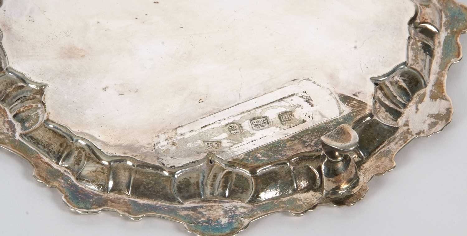 A George III silver waiter or small salver having a pie crust rim with shell motifs, supported on - Image 4 of 4