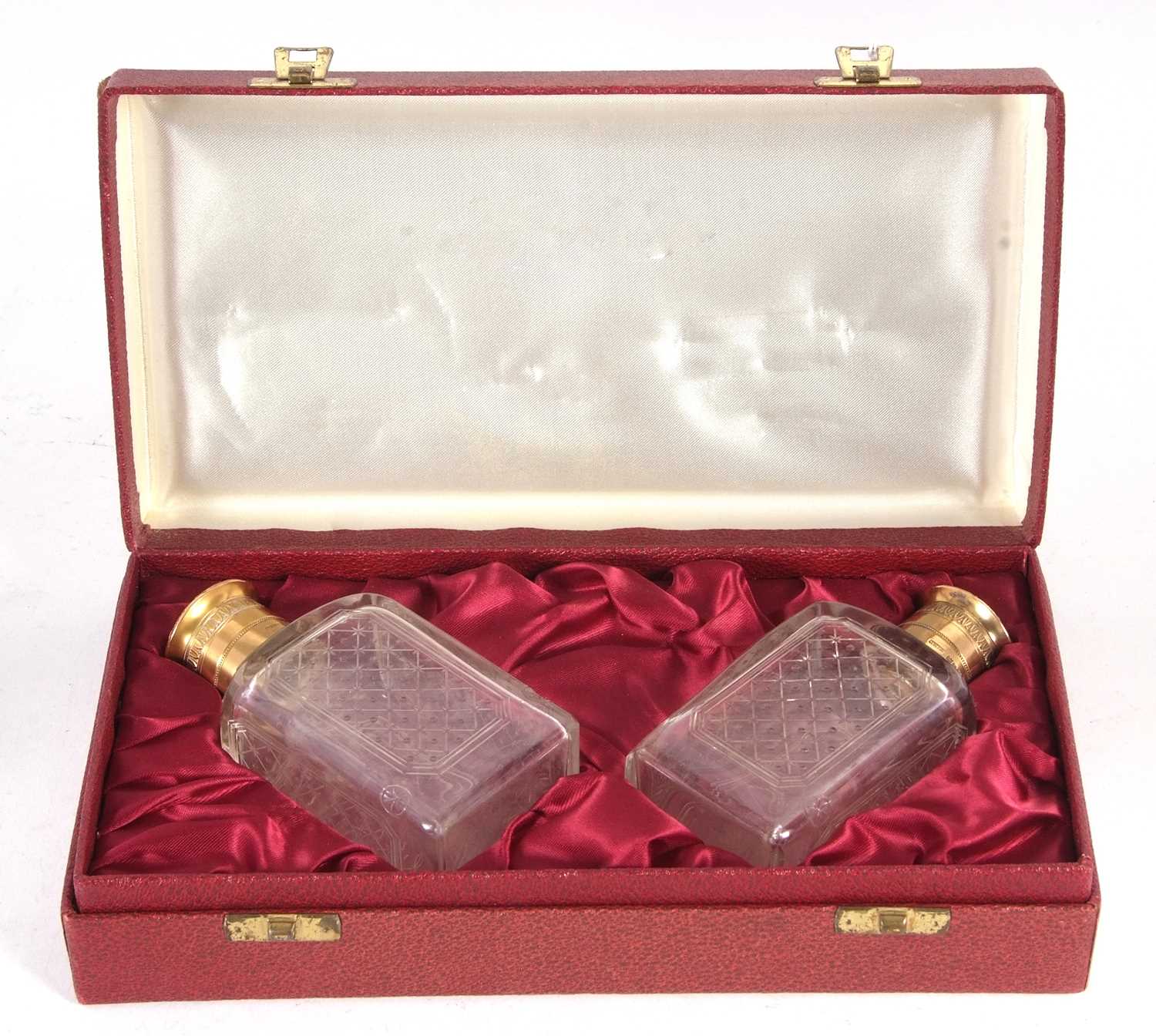 A cased pair of Asprey & Co cologne bottles, the glass etched bodies with gilt metal collars and