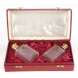 A cased pair of Asprey & Co cologne bottles, the glass etched bodies with gilt metal collars and