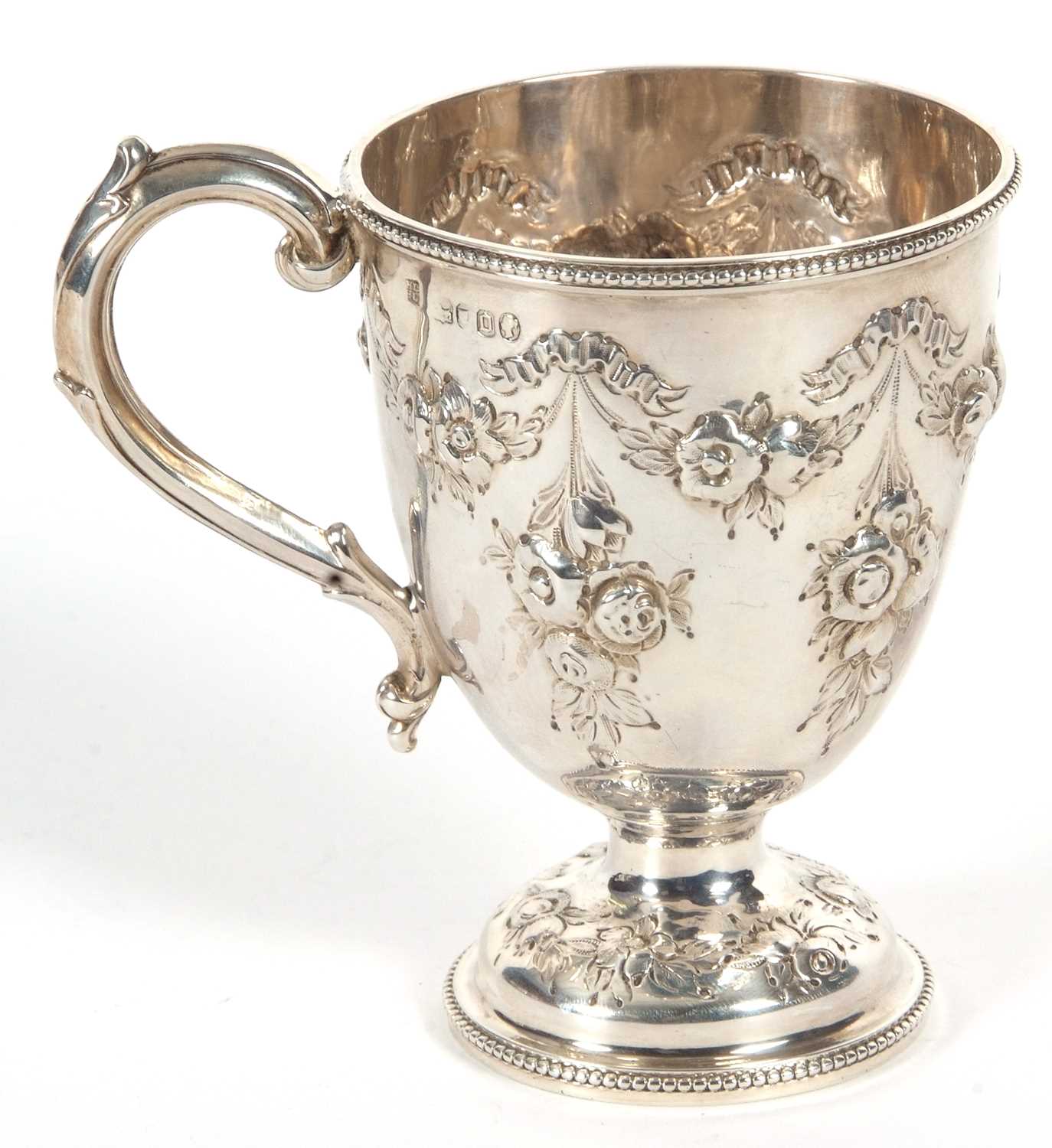 A Victorian silver mug of trophy shape having a capped scroll handle, beaded rim and foot with