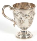 A Victorian silver mug of trophy shape having a capped scroll handle, beaded rim and foot with