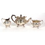 An Edwardian three piece bachelor tea service of shaped oval form, applied scroll rims on splayed