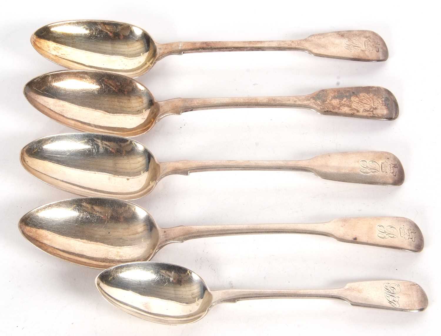 A group of four Georgian and one Victorian silver table spoon, engraved with crests and initials