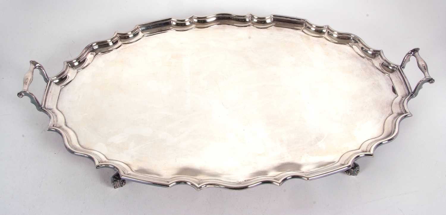 An early 20th Century large twin handled oval shaped tray with pie crust border and plain ground,