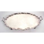 An early 20th Century large twin handled oval shaped tray with pie crust border and plain ground,