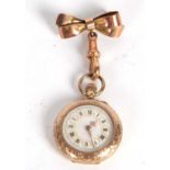 A yellow metal fob watch with 9ct bow pin, the pocket watch is stamped 14k on the inside of the case