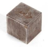 A vintage metal cube shaped paperweight/seal, one side engraved with a griffin head within a Latin