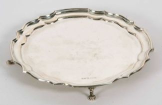 An Elizabeth II silver card salver in Georgian style of circular form with a Chippendale style