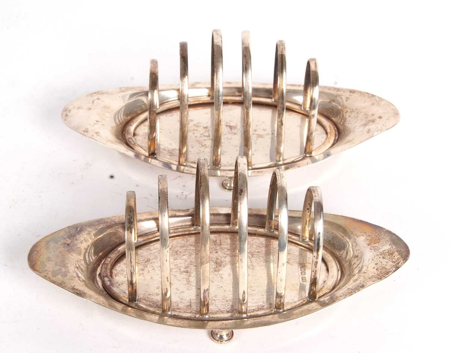 A pair of Edwardian silver toast racks, boat shaped, each with six graduated dividers, supported - Image 2 of 4