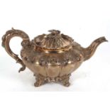 A William IV melon shaped teapot with leaf scroll handle and flower head finial, fluted body with