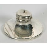 An Edwardian silver capstan ink well with integral pen rest to be base, having hinged finial lid,