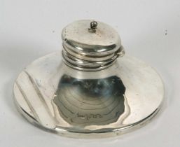 An Edwardian silver capstan ink well with integral pen rest to be base, having hinged finial lid,