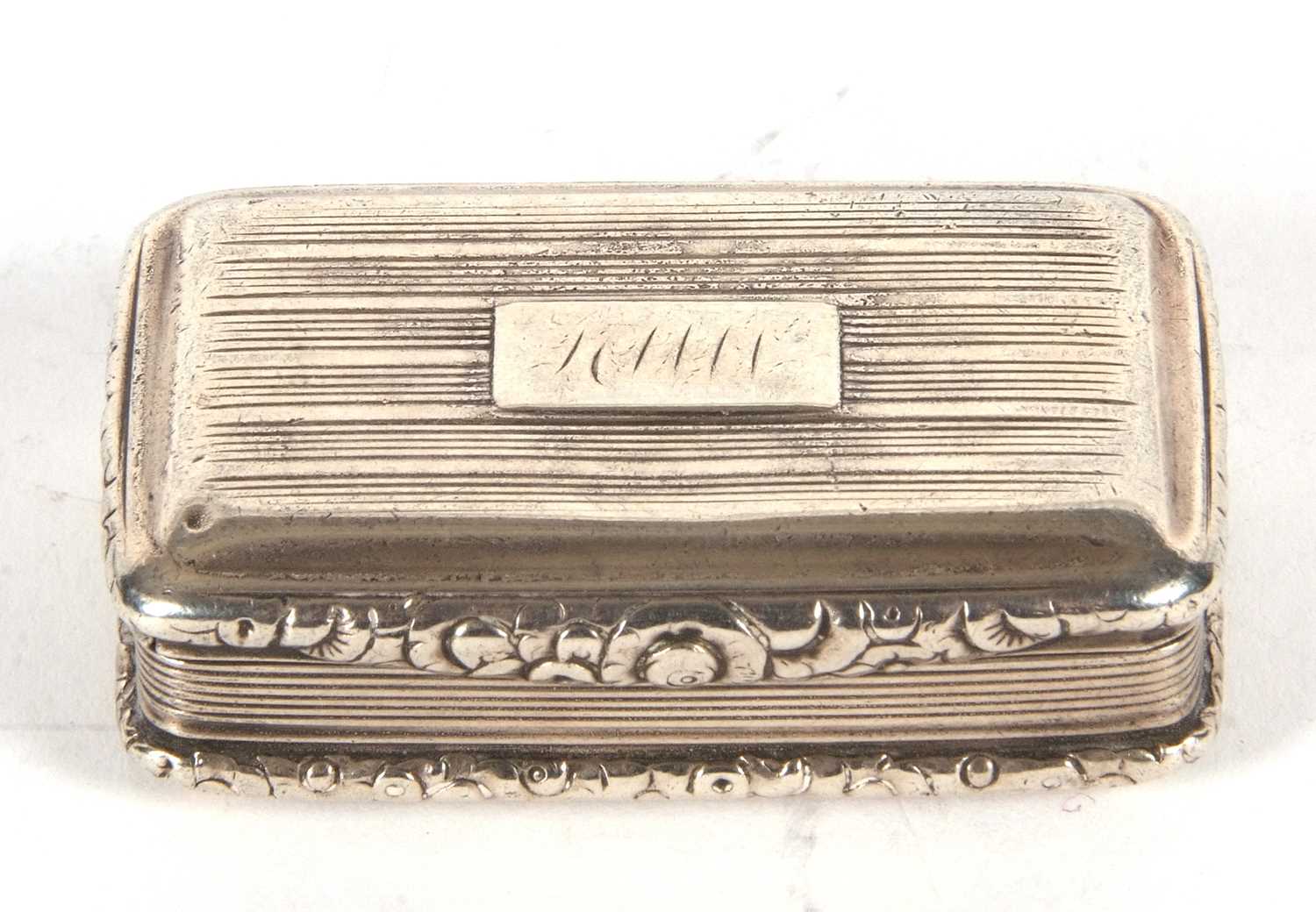 A George IV silver snuff box of rectangular form having cast foliate edges and thumb piece, engraved - Image 2 of 4