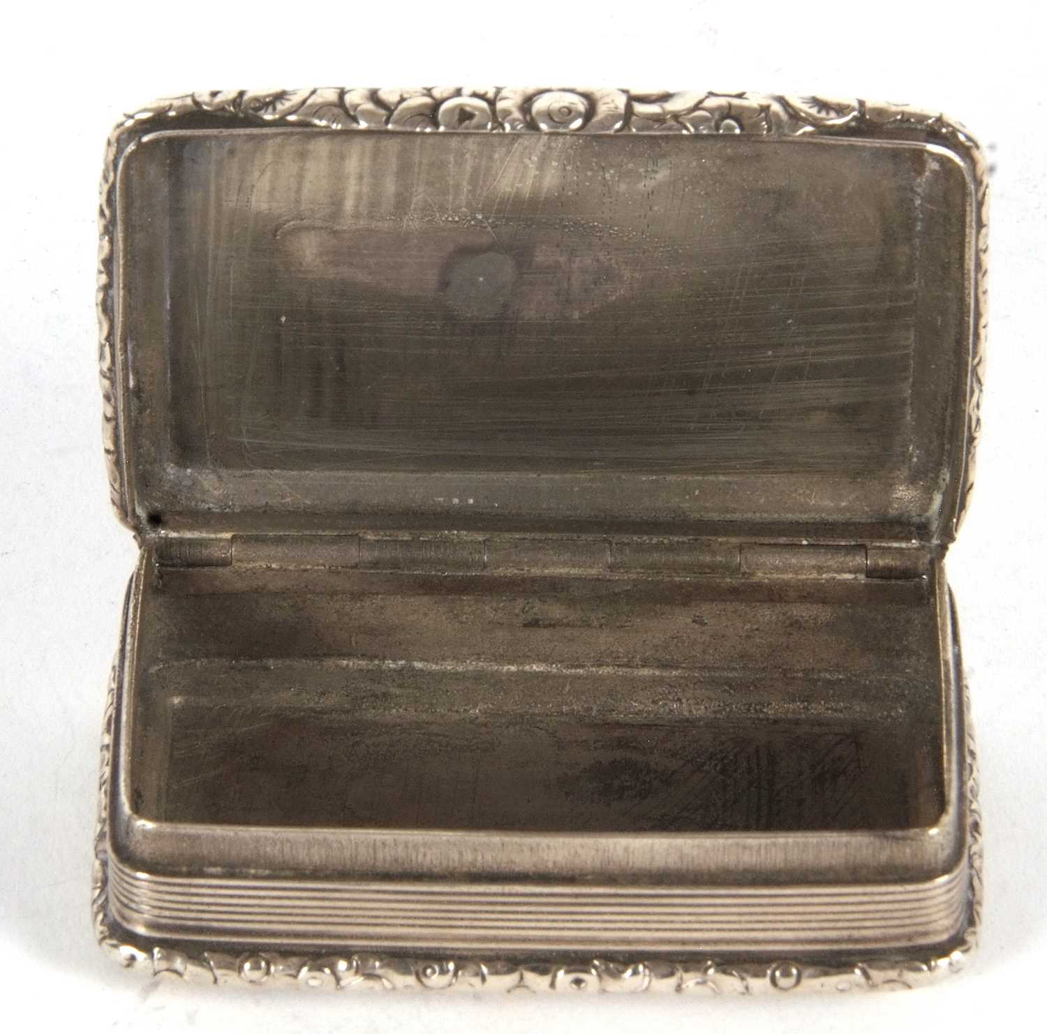 A George IV silver snuff box of rectangular form having cast foliate edges and thumb piece, engraved - Image 4 of 4
