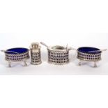 A Martin Hall & Co four piece condiment set of pierced design, each with blue glass liners and