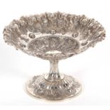 A small Victorian silver pedestal dish having a crimped rim and elaborately embossed all over with