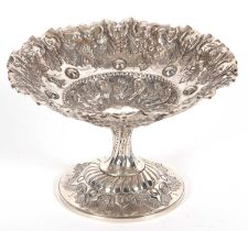 A small Victorian silver pedestal dish having a crimped rim and elaborately embossed all over with
