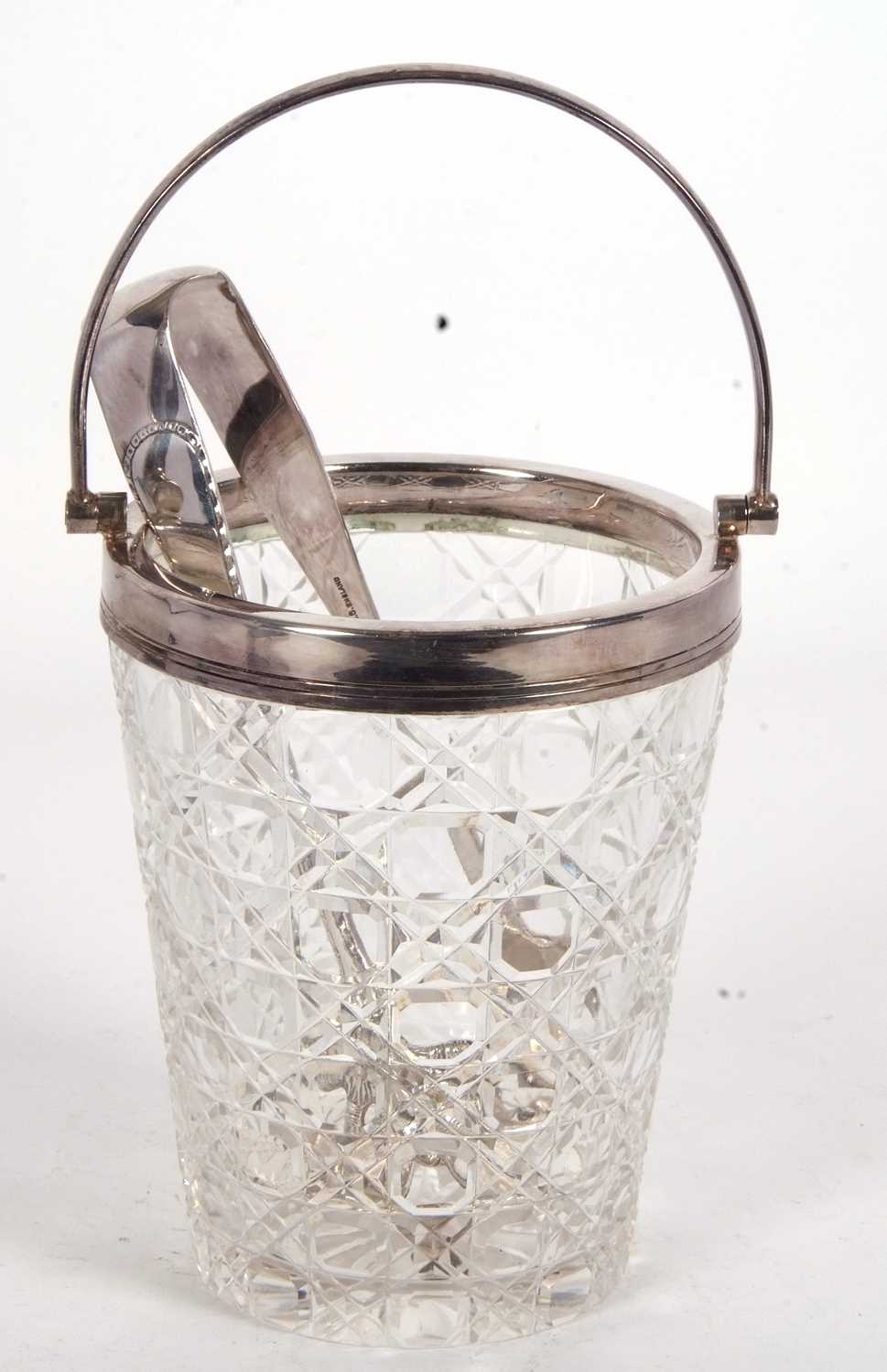 A vintage cut glass ice bucket with silver plated rim and swing handle drainer together with a