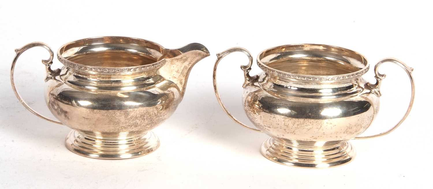 George V silver cream jug and a twin handled sugar bowl of plain squat baluster form, having a