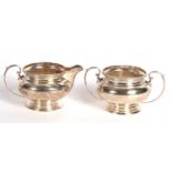 George V silver cream jug and a twin handled sugar bowl of plain squat baluster form, having a