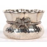 A Greek white metal small bowl of shaped circular form with spot hammered design, crimped rim and