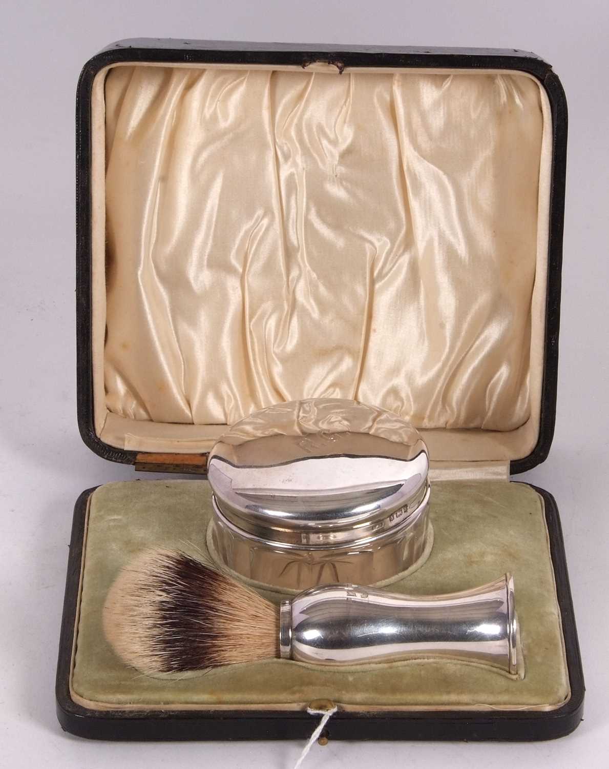 A late Victorian cased shaving silver handled brush and silver lidded pomade jar, both engraved with