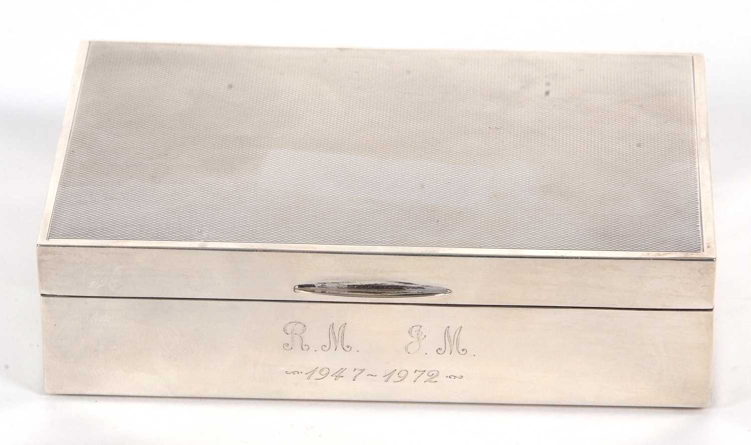 An Elizabeth II silver cigarette box of rectangular form, having an engine turned decorated lid with