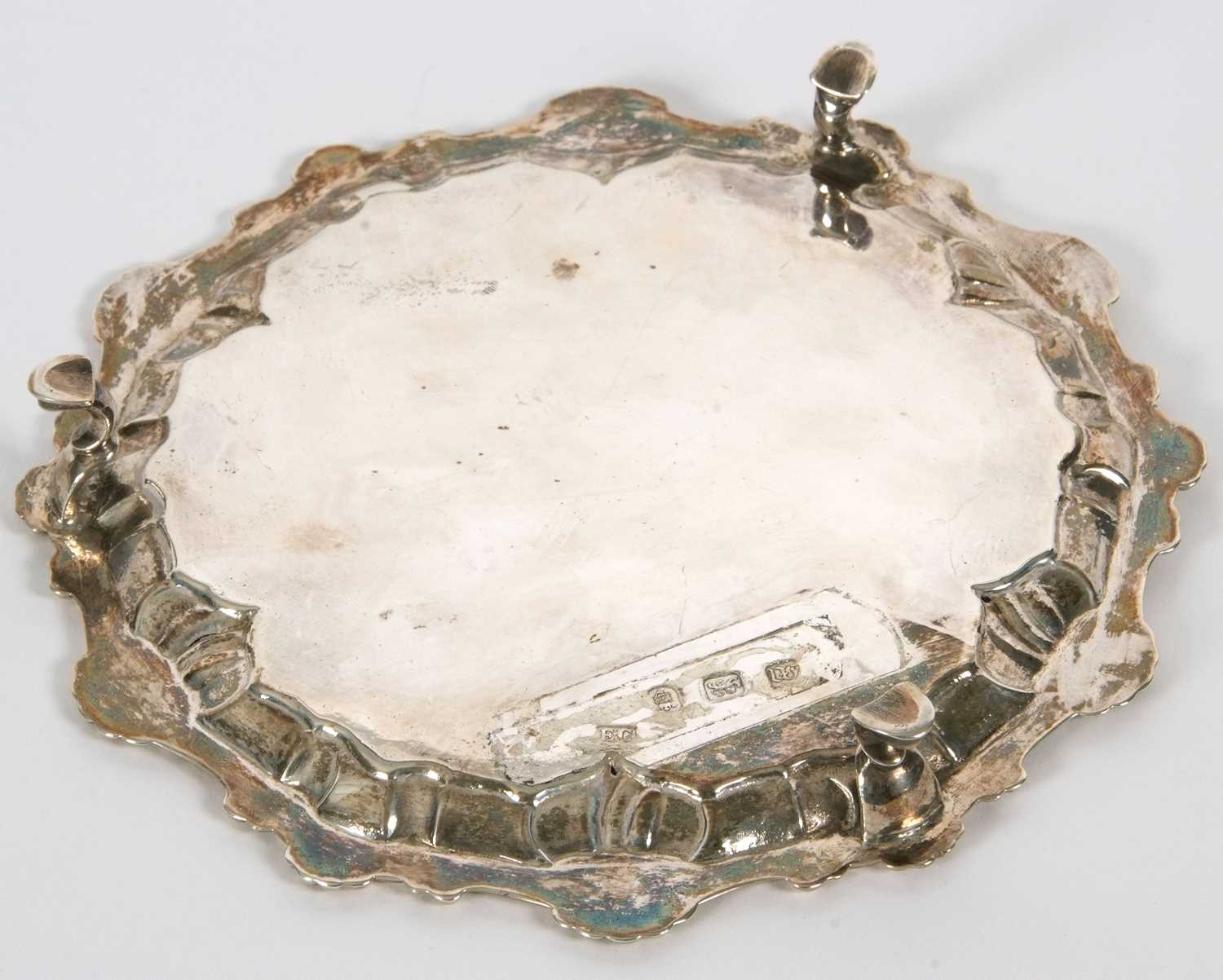 A George III silver waiter or small salver having a pie crust rim with shell motifs, supported on - Image 3 of 4