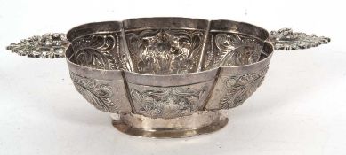 A silver twin handled dish, of lobed form decorated with flowers, scrolls etc, the handles pierced