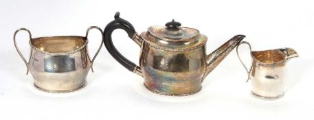 George V silver three piece bachelors tea service of plain compressed oval form with applied
