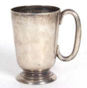 A George V silver pint tankard of slight tapering form, sea scroll handle engraved to the front with