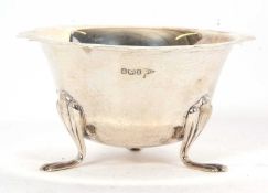 Edwardian silver sugar bowl of plain circular form with wavy rim, supported on three trefoil feet,