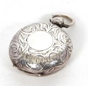 An Edwardian silver sovereign case holder, chased and engraved all over, one side with a vacant