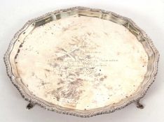 An Edward VII silver salver of shaped circular form with applied gadrooned rim, supported on four