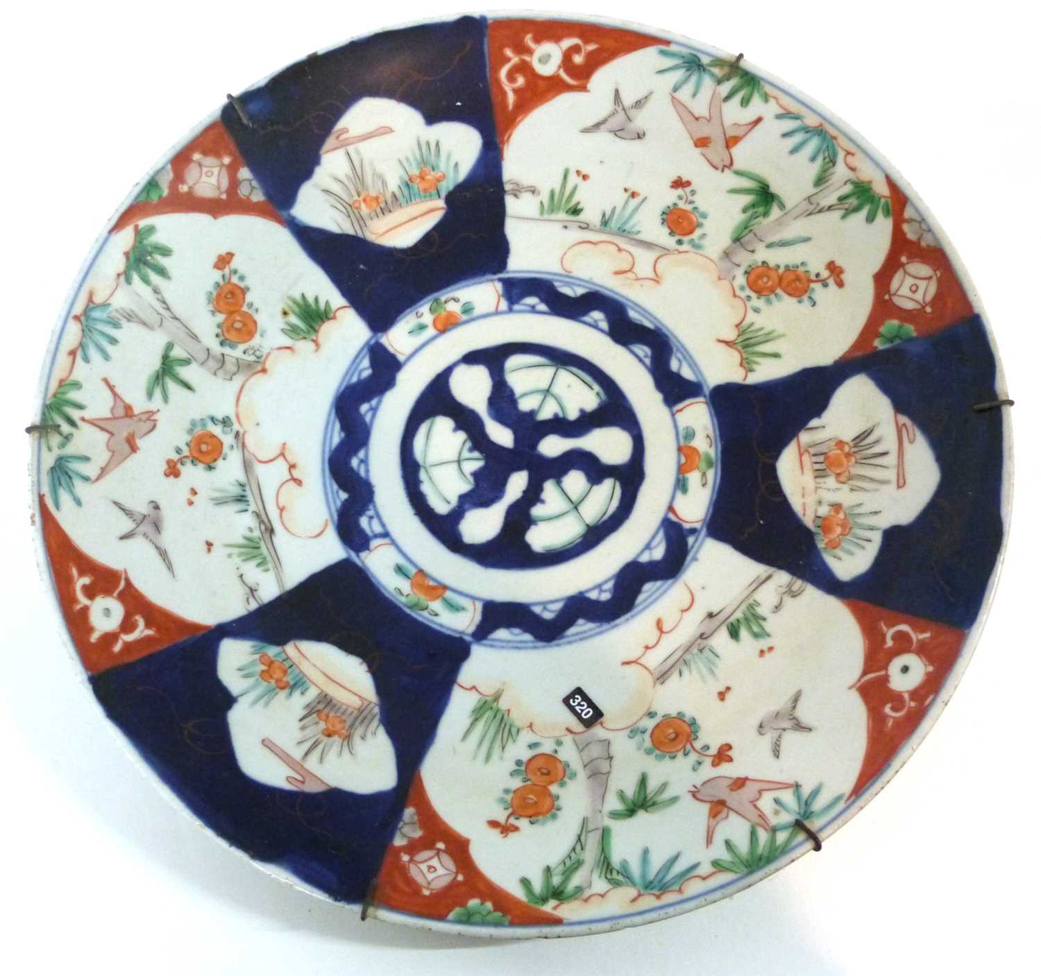 A Japanese porcelain charger with a Kakiemon design in an Imari palette