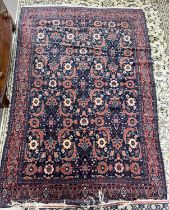 A Persian Senneh wool floor rug with large central panel decorated with geometric and floral