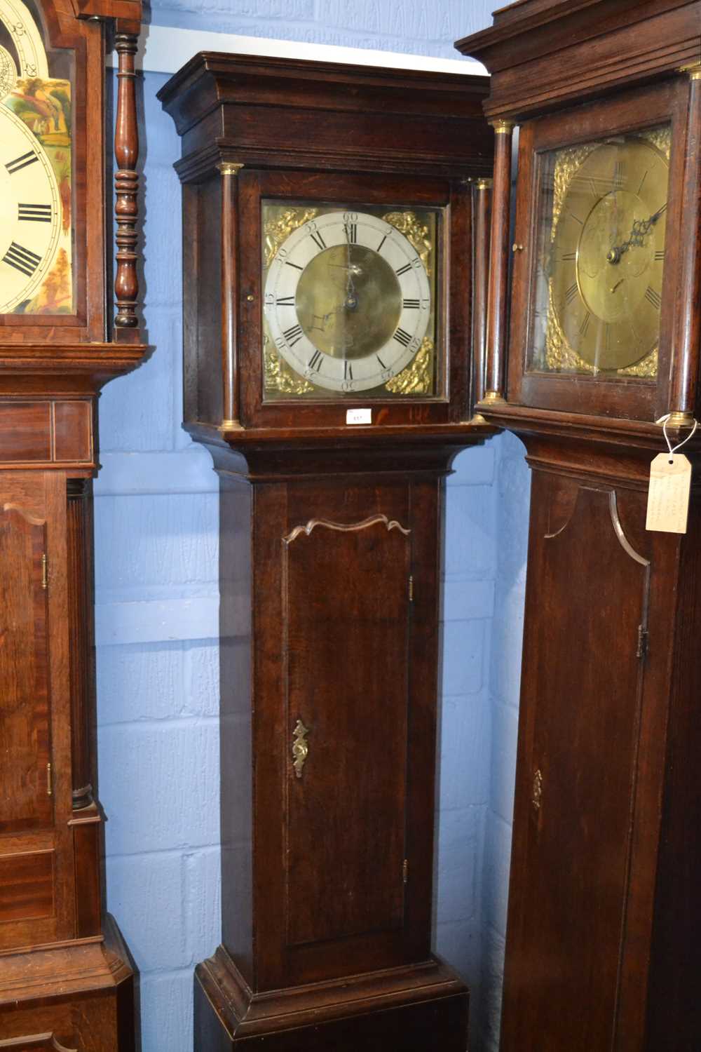 A Georgian oak cased long cased clock with square brass dial with figural spandrels, the face signed
