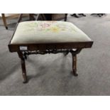 A Victorian rosewood footstool with rectangular top with tapestry covering and an "X" formed