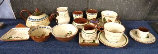 A collection of various Torquay Pottery wares, many with motto designs to include tea wares, small