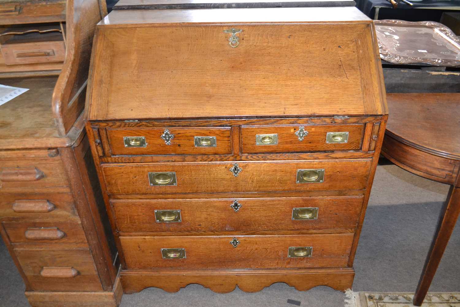 George III oak bureau of typical form with full front opening to an interior with pigeon holes and