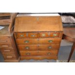 George III oak bureau of typical form with full front opening to an interior with pigeon holes and