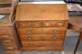 George III oak bureau of typical form with full front opening to an interior with pigeon holes and