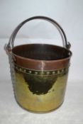 A large brass and copper coal bucket with looped iron handle, 40cm high, 42cm diameter