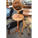 A Victorian shaving stand with adjustable circular mirror over a storage centre with two hinged