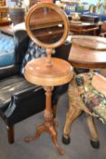 A Victorian shaving stand with adjustable circular mirror over a storage centre with two hinged