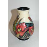 A Moorcroft vase of baluster form with tubelined design of flowers in red and black colours