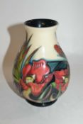 A Moorcroft vase of baluster form with tubelined design of flowers in red and black colours